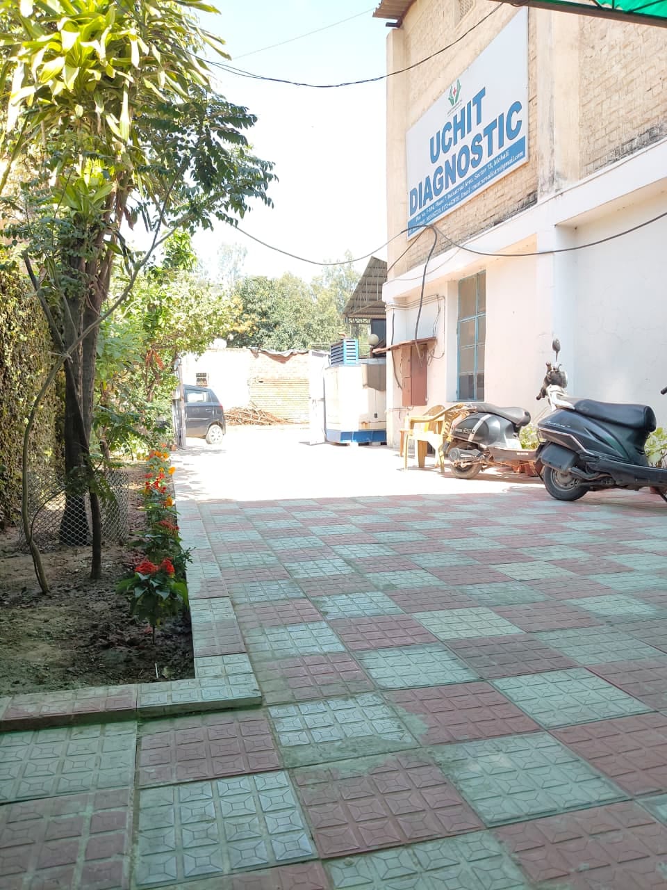 Side view of the Uchit Diagnostic building with its signboard and parking area