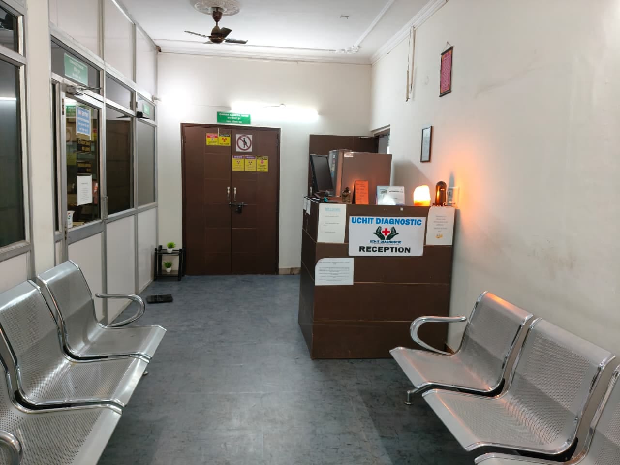 Reception desk and steel waiting chairs in the corridor at Uchit Diagnostic